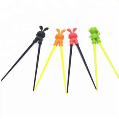 Niños aprendiendo palillos de silicona con ayuda de silicona